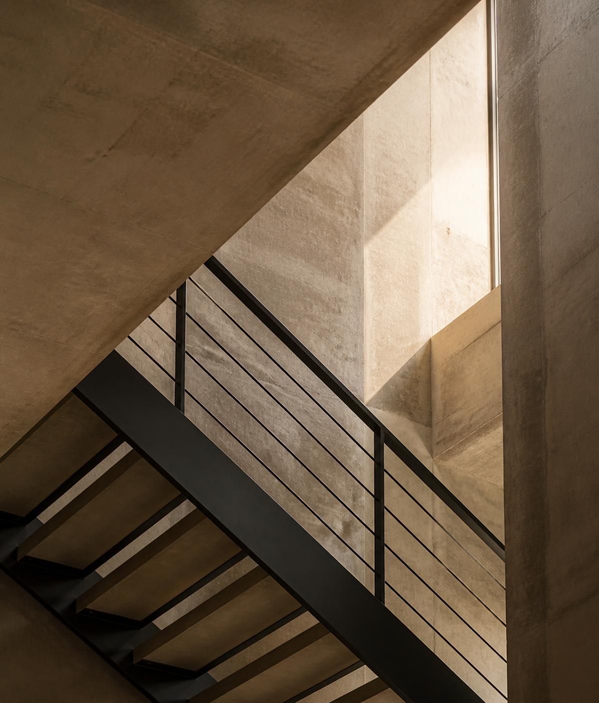 Architectural stair detail in warm concrete and steel
